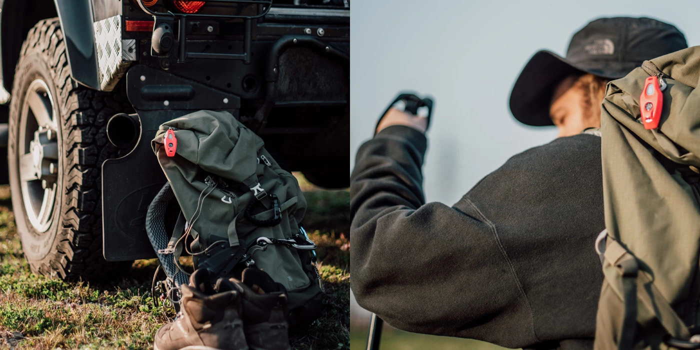 Czerwone urządzenie inMOLESS przypięte do plecaka turystycznego; widoczne w plenerze przy aucie terenowym i na plecach wędrującej osoby.